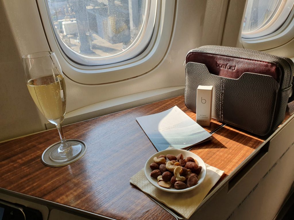 CX First Class welcome drink warm nuts and amenity kit